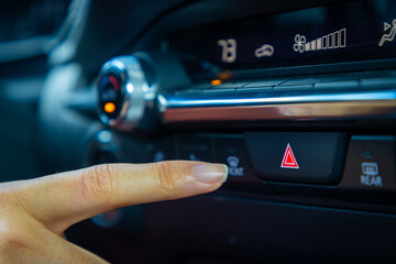 Finger reaching for emergency flasher button