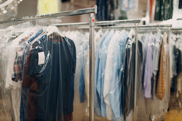 Dry cleaning clothes. Clean cloth chemical process. Laundry industrial dry-cleaning hanging clothes on rack