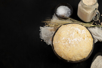 Raw dough pastry in a bowl on dark background.