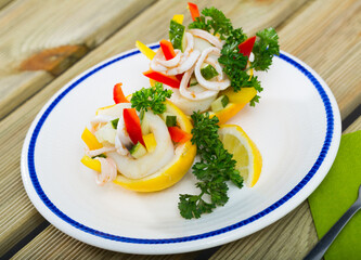 Tropical salad with squids served in lemon with cucumbers and sweet bell pepper