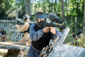 Fototapeta premium Paintball player recklessly aims with a gun on the battlefield