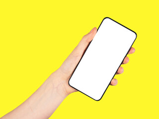 Hand holding phone mockup in rotated position on yellow background. template. Using digital technologies in modern life.