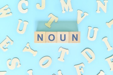 Noun or nouns concept in English grammar and learning class lesson. Wooden blocks typography word flat lay in blue background.