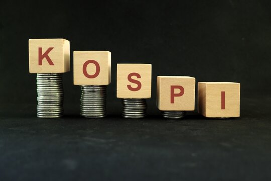 KOSPI Korean stock market index crash and bear market due to financial crisis and recession in South Korea. Wooden blocks in with coins in dark black background.