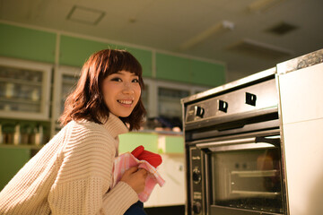 Fototapeta na wymiar オーブンで料理を作る主婦　日本人ミドル女性