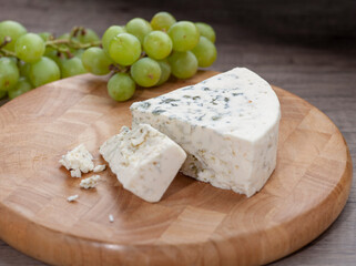 Blue Cheese on wooden cutting board with grapes