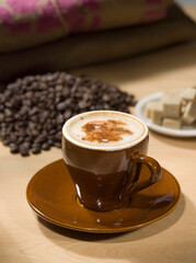 Cappuccino with coffee bean and sugar cubes on wood background