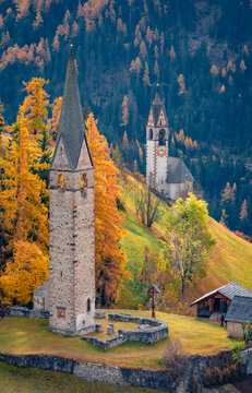 Long phocus autumn view of San Genesio and Santa Barbara churches. Majestic morning scene of Tolpei village, Province of Bolzano - South Tyrol, Italy, Europe. Traveling concept background..