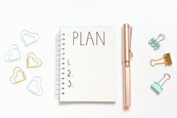 Inscription Plan in a blank notepad and stationery on white background copy space.