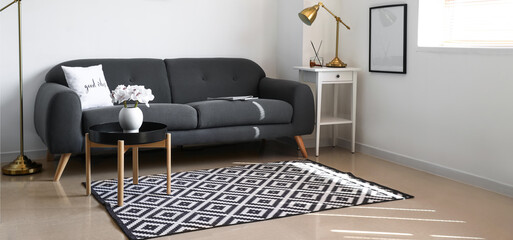 Comfortable sofa, tables and carpet in modern living room
