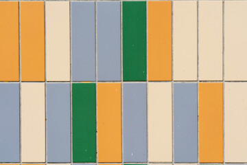 Fragment of finishing the facade of the building with ceramic tiles of different colors. Close-up. Background. Texture.