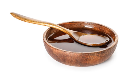 Wooden bowl and spoon with tasty maple syrup on white background