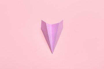 Lilac paper plane on pink background