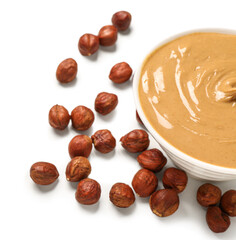 Bowl of tasty hazelnut butter on white background, closeup