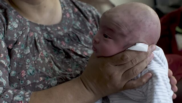 Mother Gently Holding Head Of Newborn Baby Son Whilst Rubbing His Back To Make Him Burp. Locked Off