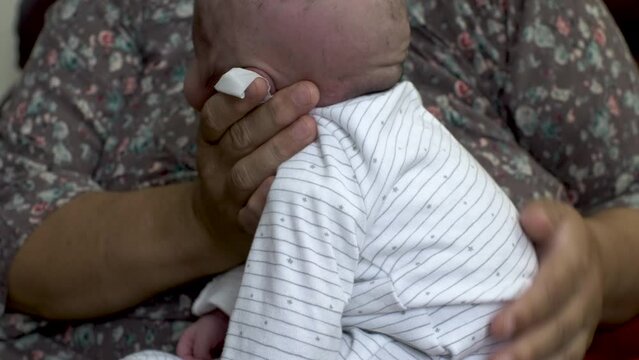 Mother holding head of newborn baby and rubbing his back for burping. Close Up, Locked off