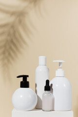 Set of natural cosmetic products on beige background with shadow of palm leaves