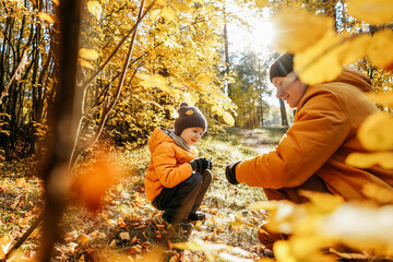 Father and son having fun in autumn forest.