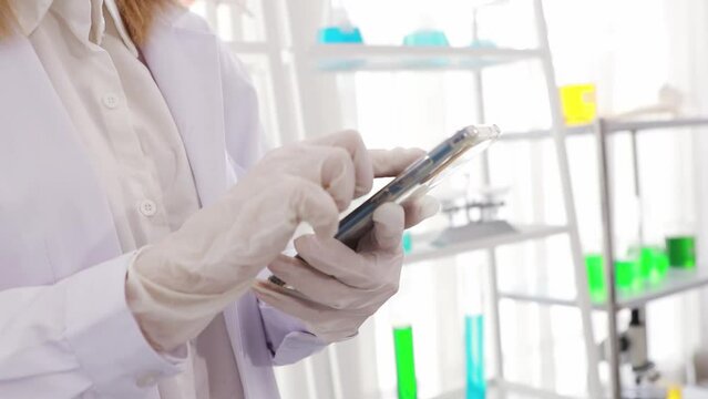 Hands of a pharmaceutical research scientist using smartphone to research research data in a lab : White researchers easily use touchscreen smartphones in the office.