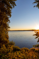 Sunset scenery on an autumn evening in Finland. Lake shore wallpaper concept image. Some flare effect added to images.