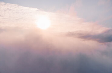 Aerial view. The drone flies over foggy and fluffy clouds. Blue sky sun and sea fog. Abstract aerial nature summer ocean sunset sea and sky background. Vacation, travel and holiday concept