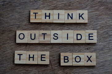 think outside the box text on wooden square, inspiration and motivation quotes