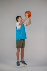 A boy in sporstwear with ball in hands