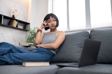 A girl sitting on the sofa with a laptop and looking busy