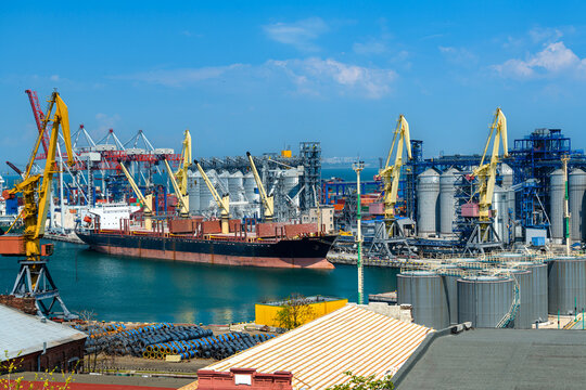 industrial seaport infrastructure, sea, cranes and dry cargo ship, grain silo, bulk carrier vessel and grain storage elevators, concept of maritime cargo transportation