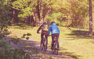 Fototapeta premium Cyclists ride on the bike path in the city Park 