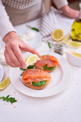 woman squeezing lemon juice on a Cream cheese and Smoked salmon toast