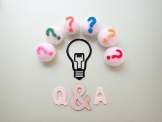 Q&Aの単語、電球の周りにカラフルなクエスチョンマークがたくさん