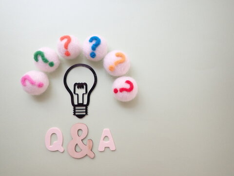 Q&Aの単語、電球の周りにかわいいクエスチョンマークがたくさん、コピースペース