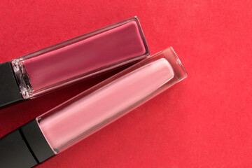 Lip glosses on red background
