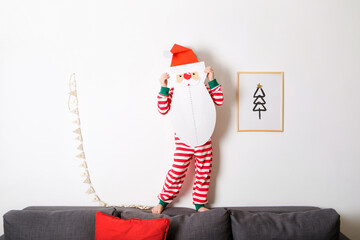 advent calendar in form of Santa Claus beard in hands of child against white wall. christmas craft for kids. cut off piece of beard with number every day in anticipation of holiday