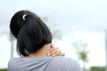 Women have neck pain, shoulder pain, at the park health concept.