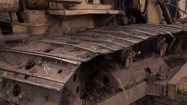 Close up view on bulldozer's undercarriage during pushing ground at construction site