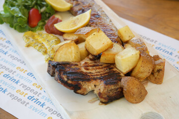 Pancetta pork belly steak served with crispy potatoes and honey mustard