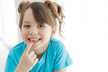 The child has lost a tooth. Little girl without a tooth. The first tooth fell out. High quality photo