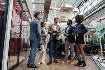 Multiethnic group of business people talking in office during break. Teamwork concept