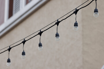 string wired bulbs decoration outdoor of building. garland of a light bulbs. concept : city...