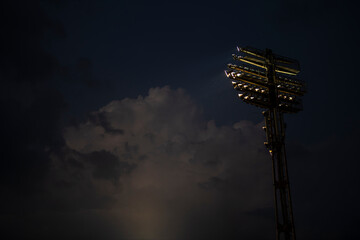 Soccer stadium lights reflectors with clouds in background. Football field.