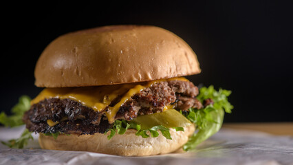 Close-up Tasty burger with beef,  pickled, onion, lettuce and sauce