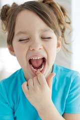 The child has lost a tooth. Little girl without a tooth. The first tooth fell out. High quality photo