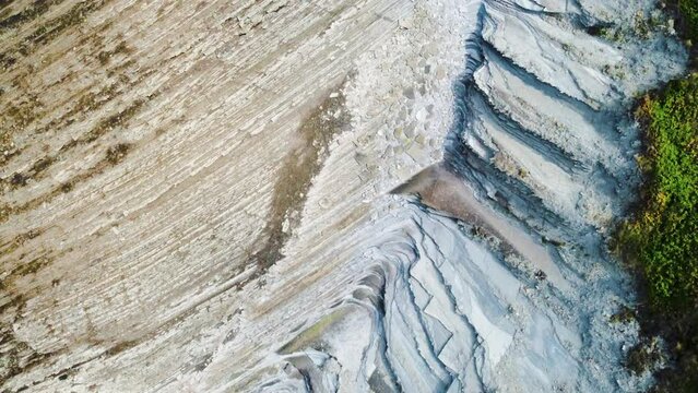 Aerial view of Flysch Route in Spain Basque country top down of beach pattern due wind rock stone erosion geological formation 