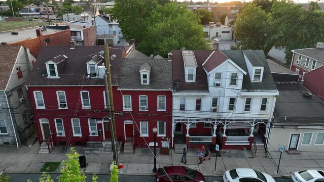 Crime in USA. Gang walks street by homes in downtown. Aerial summer sunset view.