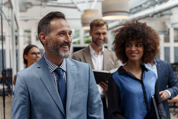 Multiethnic group of business people standing in office during break. Teamwork concept