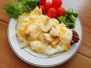 scrambled eggs with vegetables and cheese on a plate