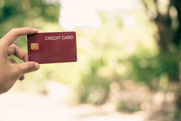 Credit Card. hand holding credit card with green nature background and copy space concept online...