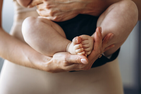 Baby feet in mothers hands, close up photo
